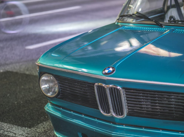 BMW car with a clear headlight and shiny turquoise paint, parked on a city street in the UAE