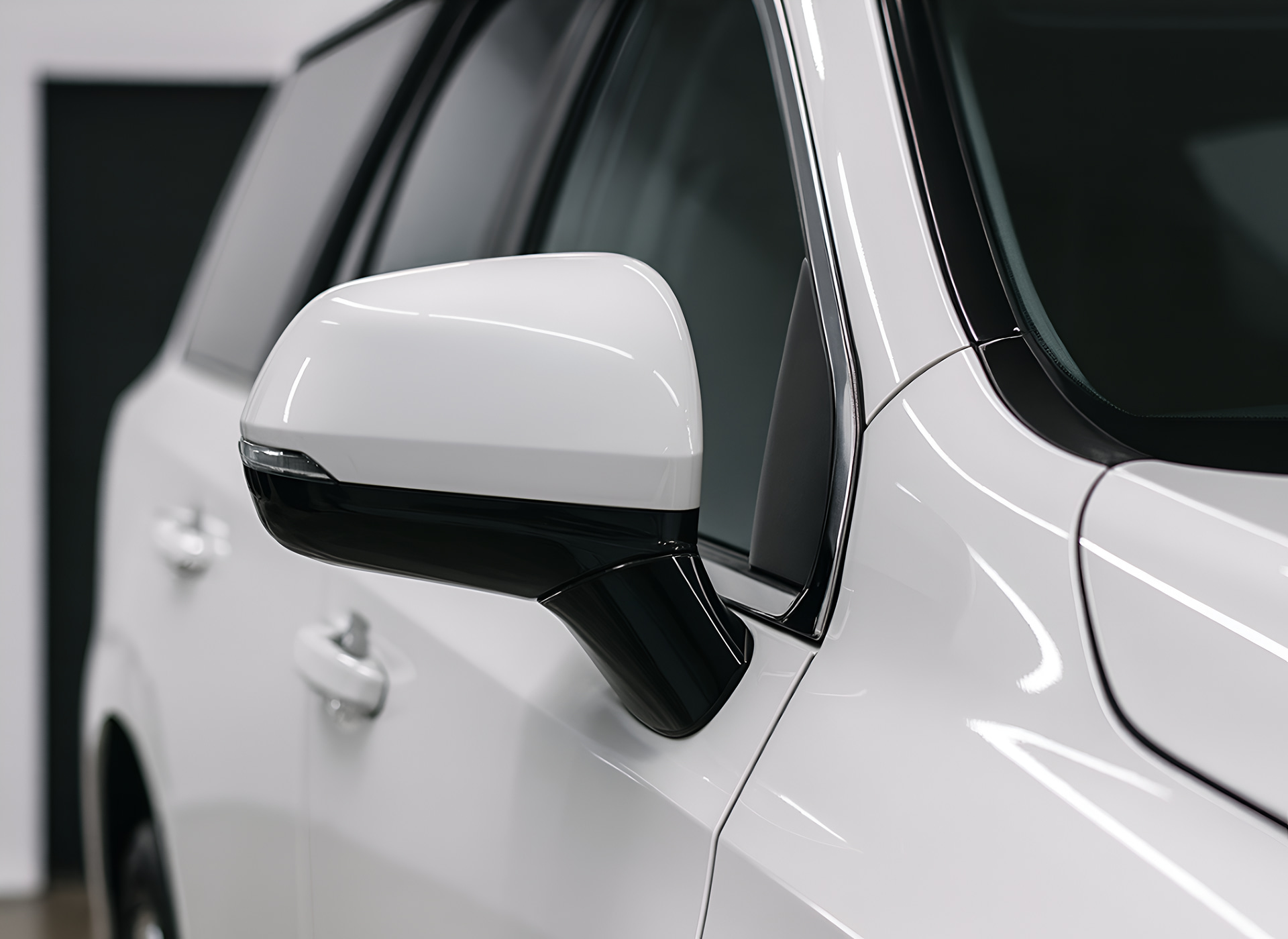Close-up of a white car side mirror and door panel with glossy reflections