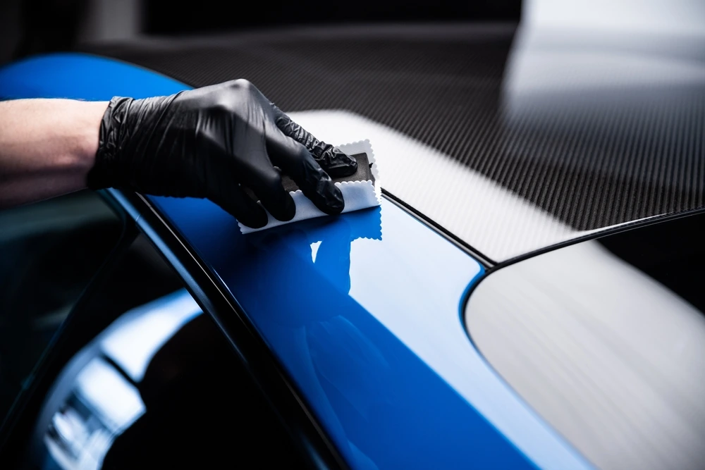 Professional technician applying protective coating during car detailing service in Sharjah