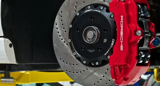 Red painted brake caliper on a drilled and slotted disc rotor